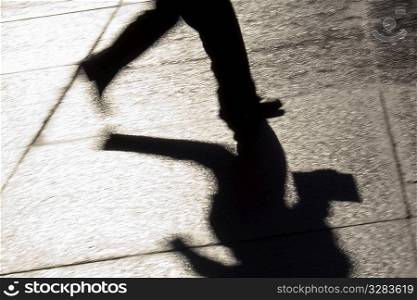 Silhouette of businessman running downtown.