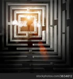 Silhouette of businessman standing in maze sun above