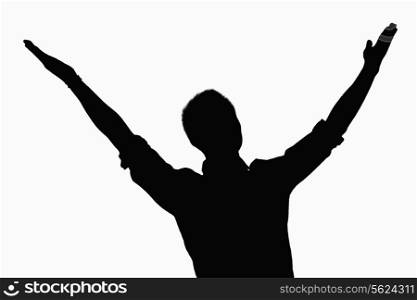 Silhouette of businessman with arms raised.