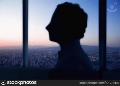 Silhouette of businessman with sunset and cityscape behind him