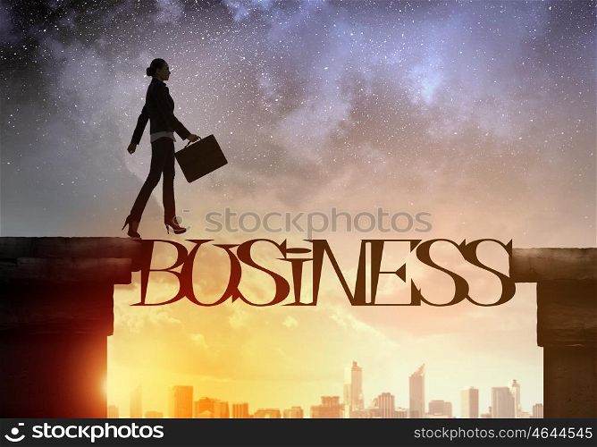 Silhouette of businesswoman over sunrise. Businesswoman running on business word bridge over precipice