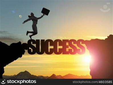 Silhouette of businesswoman over sunrise. Businesswoman running on success word bridge over precipice