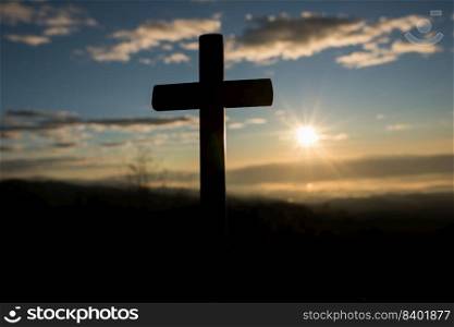 Silhouette of catholic cross and sunrise