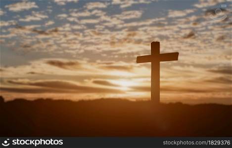 Silhouette of catholic cross at sunset background.