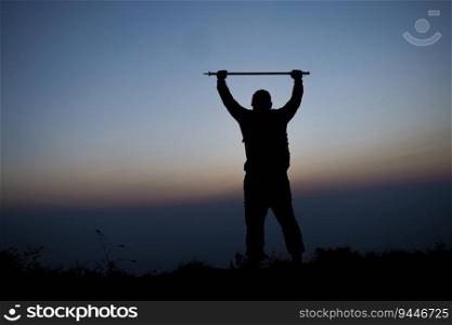 Silhouette of cheering hiking man open arms to the sunrise stand on mountain. Travel Lifestyle wanderlust adventure concept summer vacations outdoor.