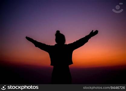 Silhouette of cheering hiking woman open arms to the sunrise stand on mountain. Travel Lifestyle wanderlust adventure concept summer vacations outdoor.