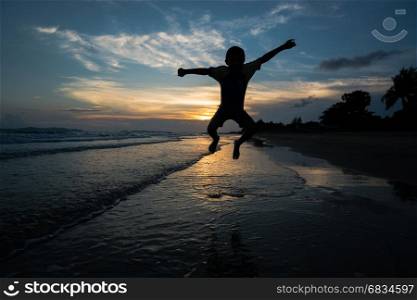 Silhouette of child jumping on the beach