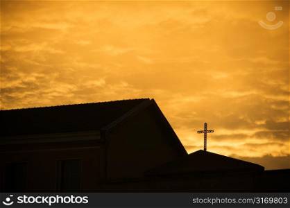 Silhouette of Church With Cross Against Golden Sky