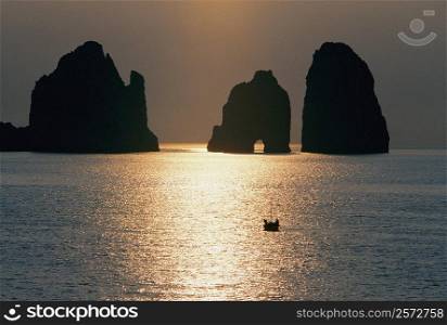 Silhouette of cliffs in the sea during sunrise, Capri, Italy