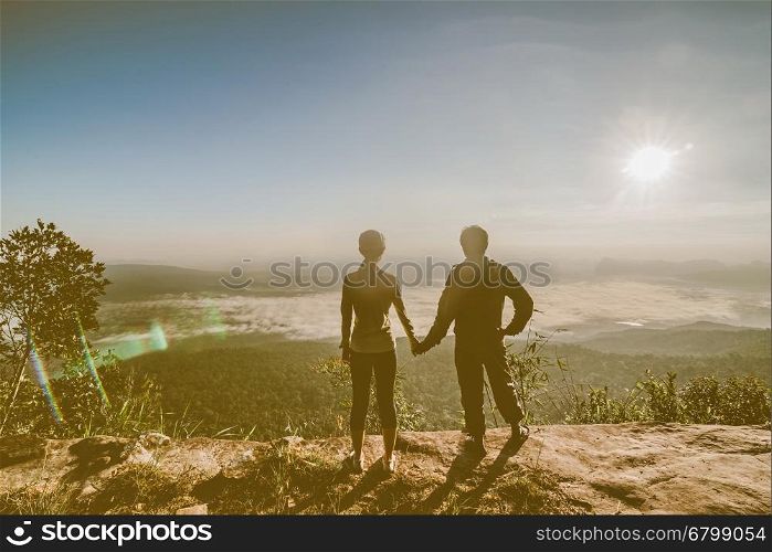 silhouette of couple hiker open arms at mountain peak
