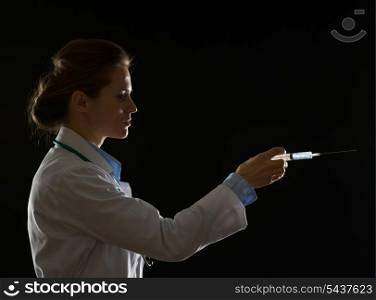 Silhouette of doctor woman using syringe isolated on black