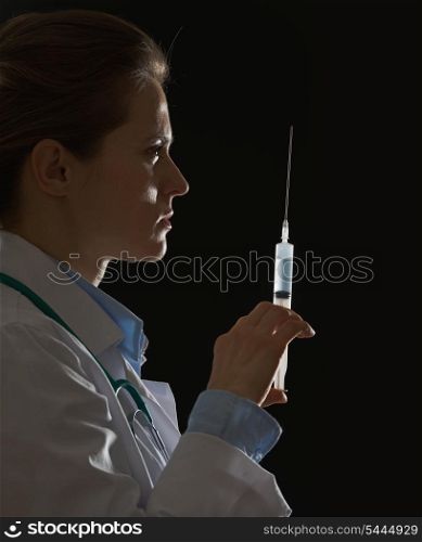 Silhouette of doctor woman with syringe on black background