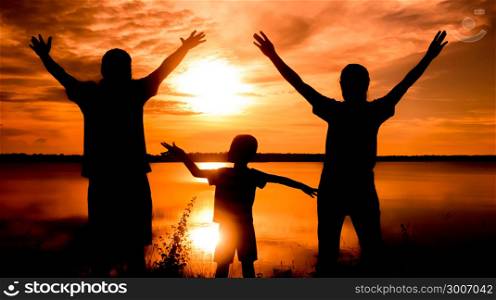 silhouette of family. Happy family standing on the dawn time . sunset in nature
