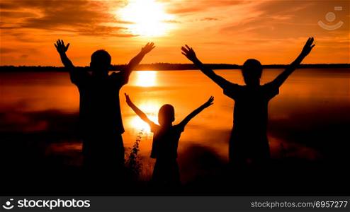 silhouette of family. Happy family standing on the dawn time . sunset in nature
