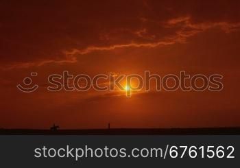 Silhouette of female rider riding horse on the horizon at sunset