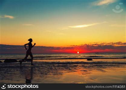 Silhouette of female runing along the sea coast