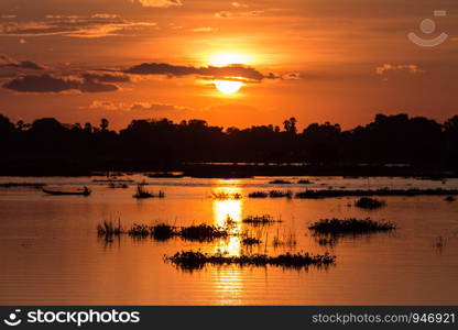 Silhouette of fisherman to drive a boat on the lake at sunset scene in Mandalay, Myanmar