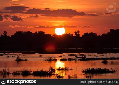 Silhouette of fisherman to drive a boat on the lake at sunset scene in Mandalay, Myanmar