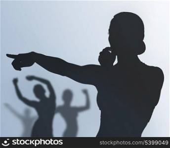 silhouette of fitness instructor and training people