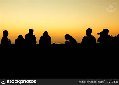 silhouette of group of friends standing in sunset