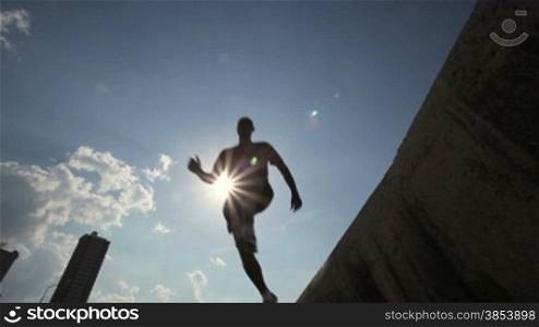 Silhouette of group of young people running and jumping in Havana, Cuba. Low angle view
