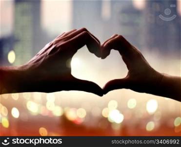 Silhouette of hands in form of heart when sweethearts have touched