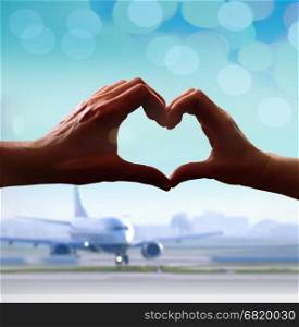 Silhouette of hands in form of heart when sweethearts have touched at airport