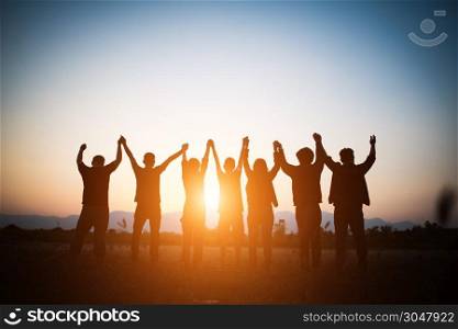 Silhouette of happy business human team making high hands over head in sunset sky evening time background for business teamwork concept and freedom