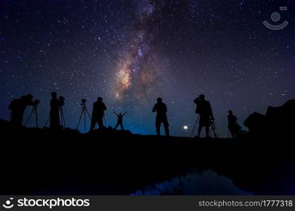 Silhouette of happy man standing on a hill with Milky Way has stars and the night sky.. Silhouette man and Milky way
