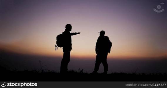 Silhouette of Hiker men with backpack stay on cliff and think on the top mountain at sunset. Travel Lifestyle wanderlust adventure concept summer vacations outdoor.