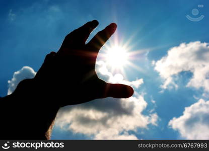 Silhouette of human hand reach to sun. Conceptual design.