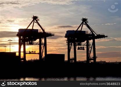 silhouette of Industrial ship in Terminal port with sunrise