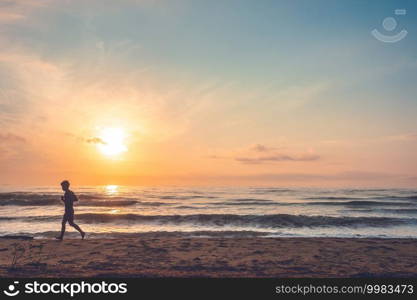 silhouette of jogging man on beach in the morning at sunrise.