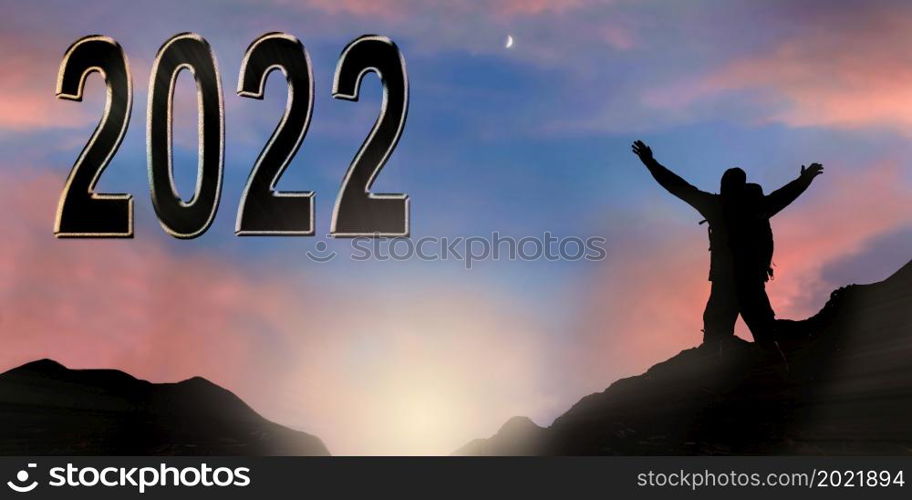silhouette of man enjoy standing in mountain in front of figures 2022 on sunset sky background