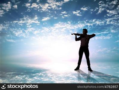 Silhouette of man playing violin high in sky. Man violinist