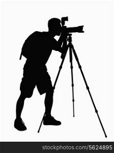 Silhouette of man taking pictures with camera on tripod.