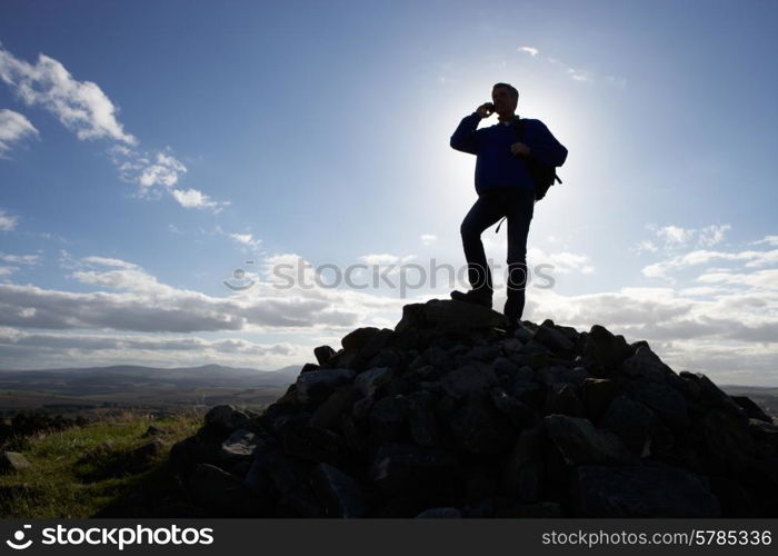 Silhouette Of Man Using Mobile Phone In Remote Countryside