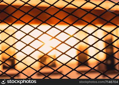 Silhouette of metal grille and light of sunset