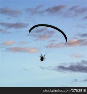 Silhouette of paragliding on beautiful sky background