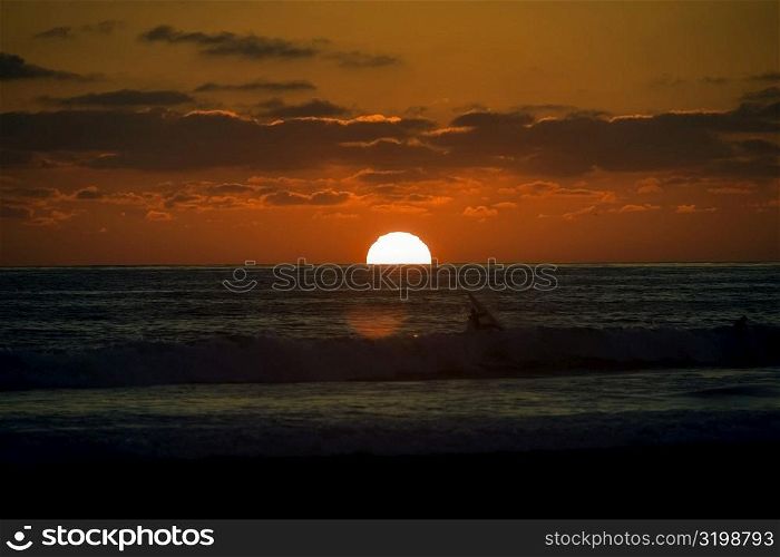 Silhouette of people in the sea at dusk, San Diego, California, USA