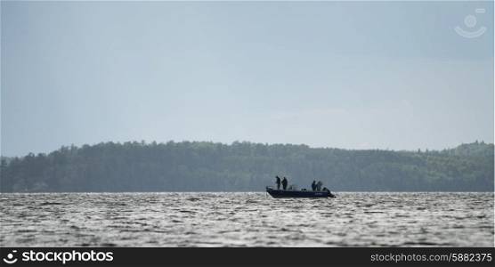 Silhouette of people on boat in a lake, Lake of the Woods, Ontario, Canada