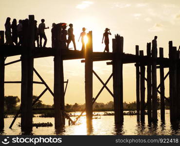 Silhouette of people walking on Bridge U-Bein at sunset scene