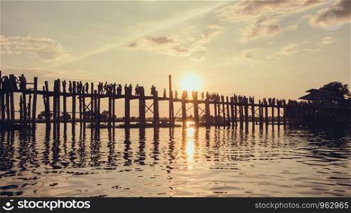 Silhouette of people walking on Bridge U-Bein at sunset scene