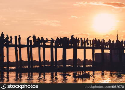 Silhouette of people walking on Bridge U-Bein at sunset scene