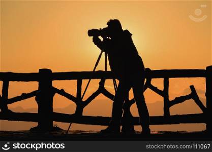 silhouette of photographer taking picture of landscape