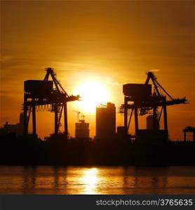 Silhouette of port warehouse with container cargo and crane bridge
