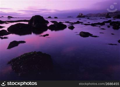 Silhouette of rocks by sea