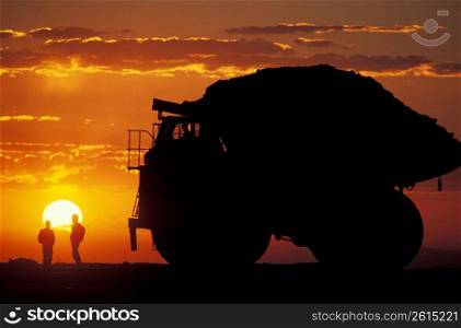 Silhouette of silver and gold truck drivers