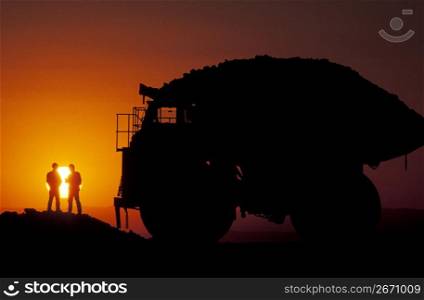 Silhouette of silver and gold truck drivers