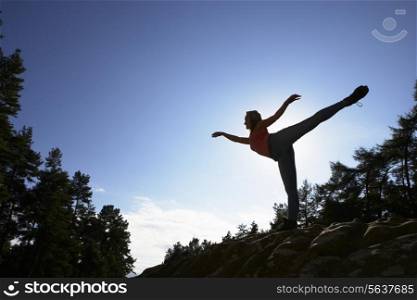 Silhouette Of Teenage Girl Balancing On Rock